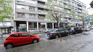 Un immeuble résidentiel à plusieurs étages, doté de balcons, d’un espace de stationnement et d’un chemin piétonnier.
