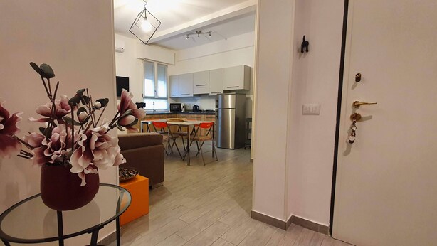 Eine moderne Küche mit weißen Schränken, einem Edelstahl-Kühlschrank und einem Essbereich mit Tisch und Stühlen.