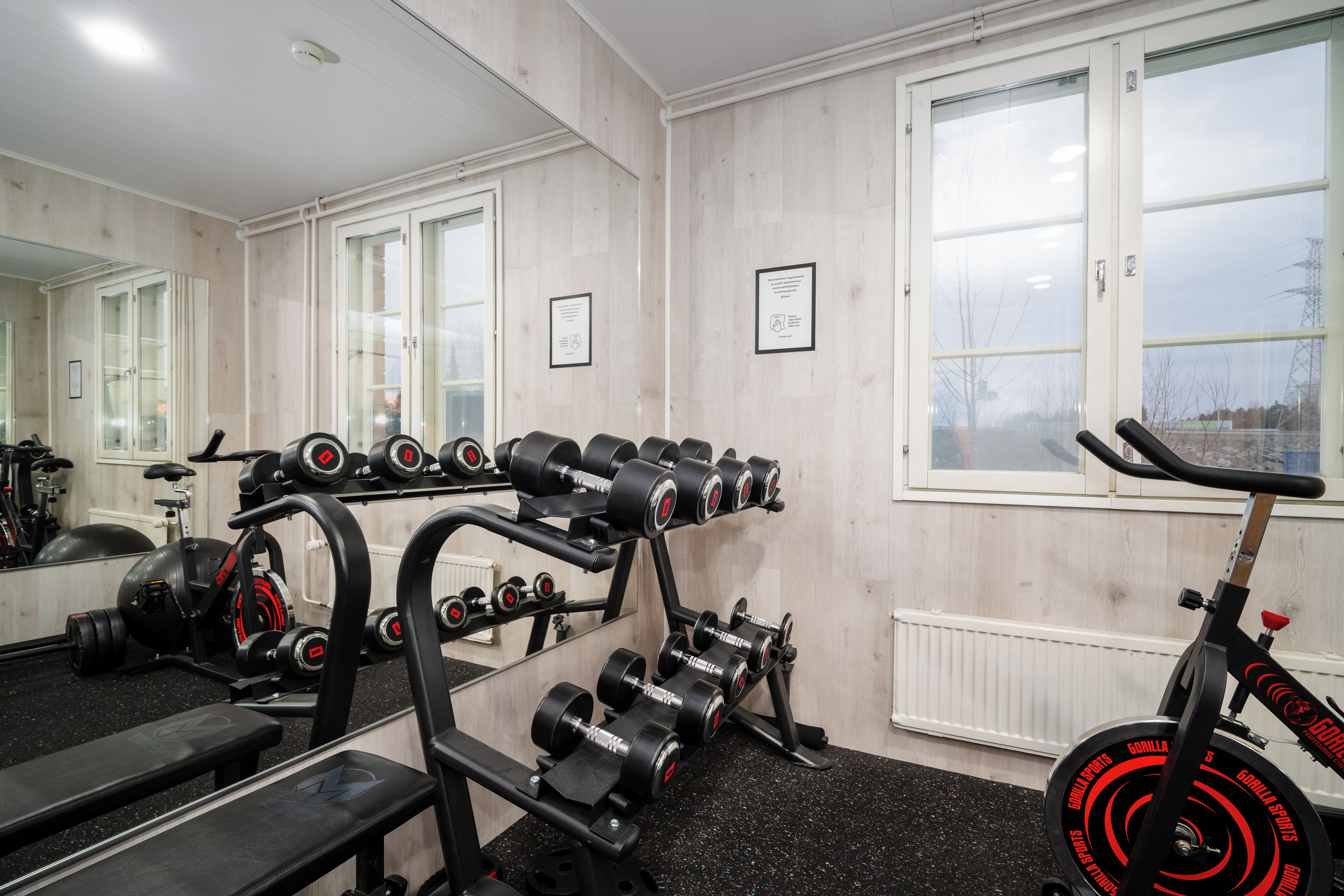 Une salle de sport équipée de matériel de musculation, d’un banc et d’un vélo d’appartement.