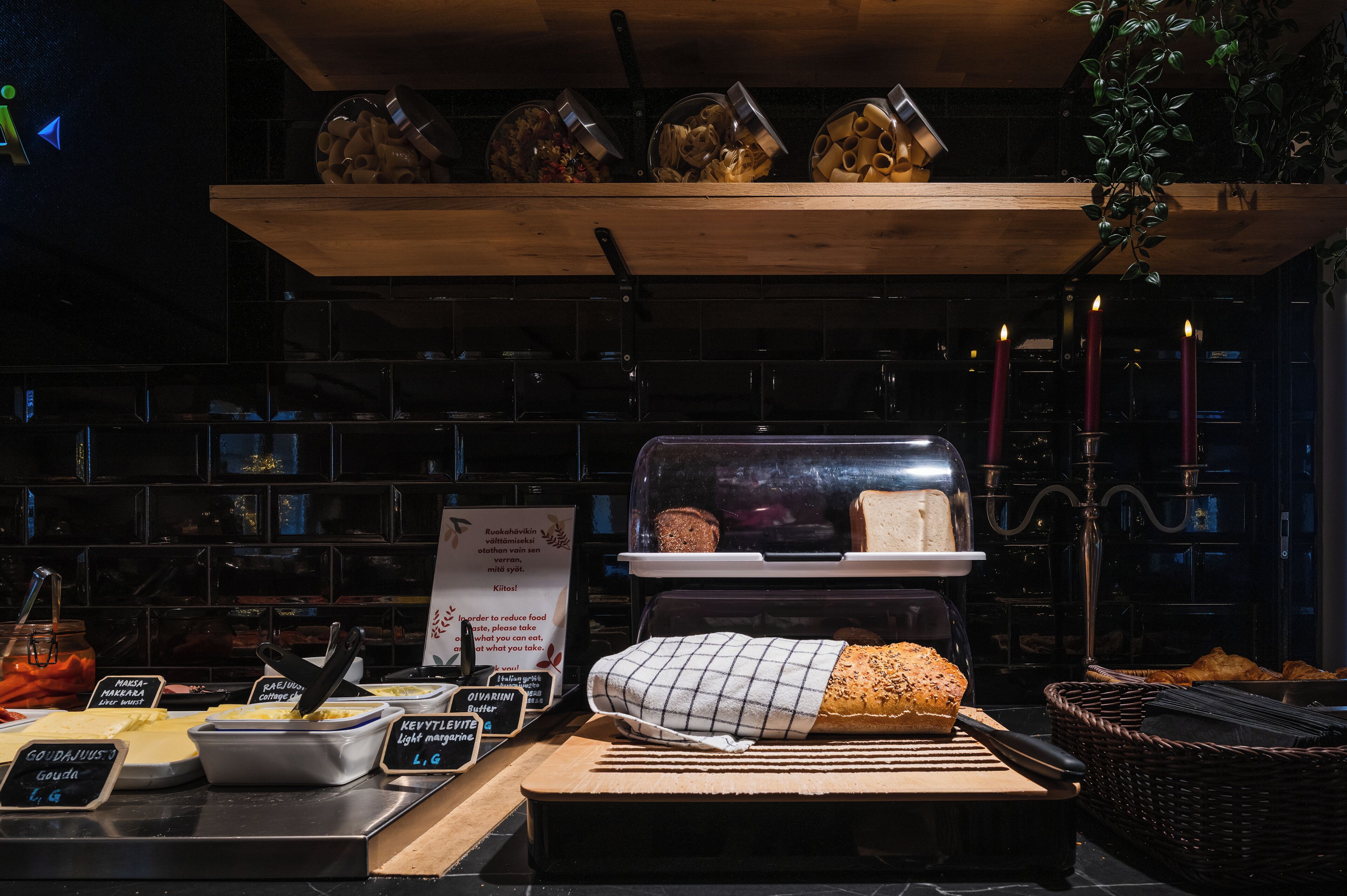A bakery display with bread, pastries, and a sign about reducing food waste.