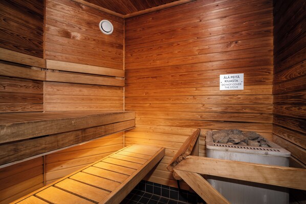 A sauna with wooden benches and a sign in a foreign language.