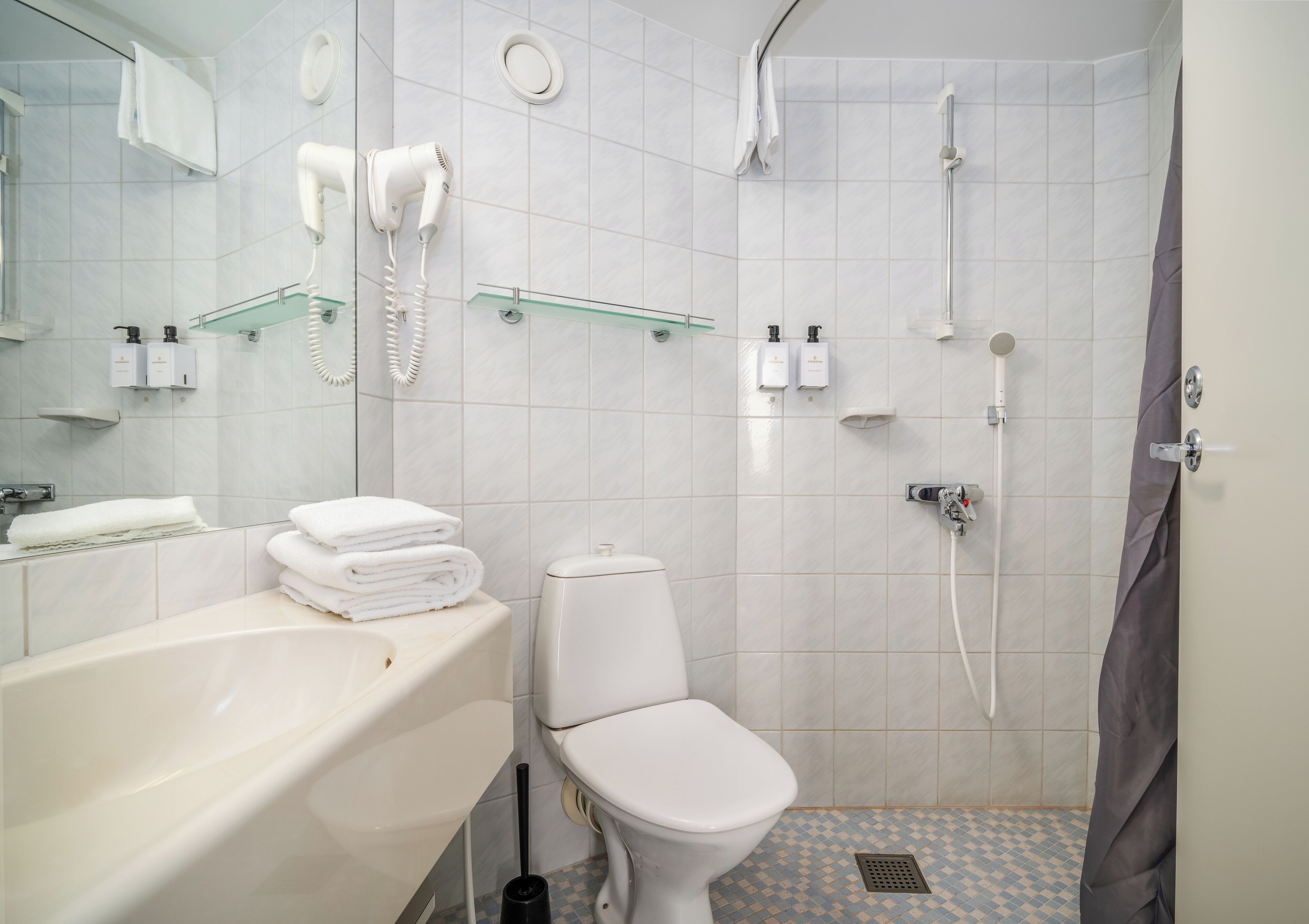 A bathroom with a toilet, sink, and shower.
