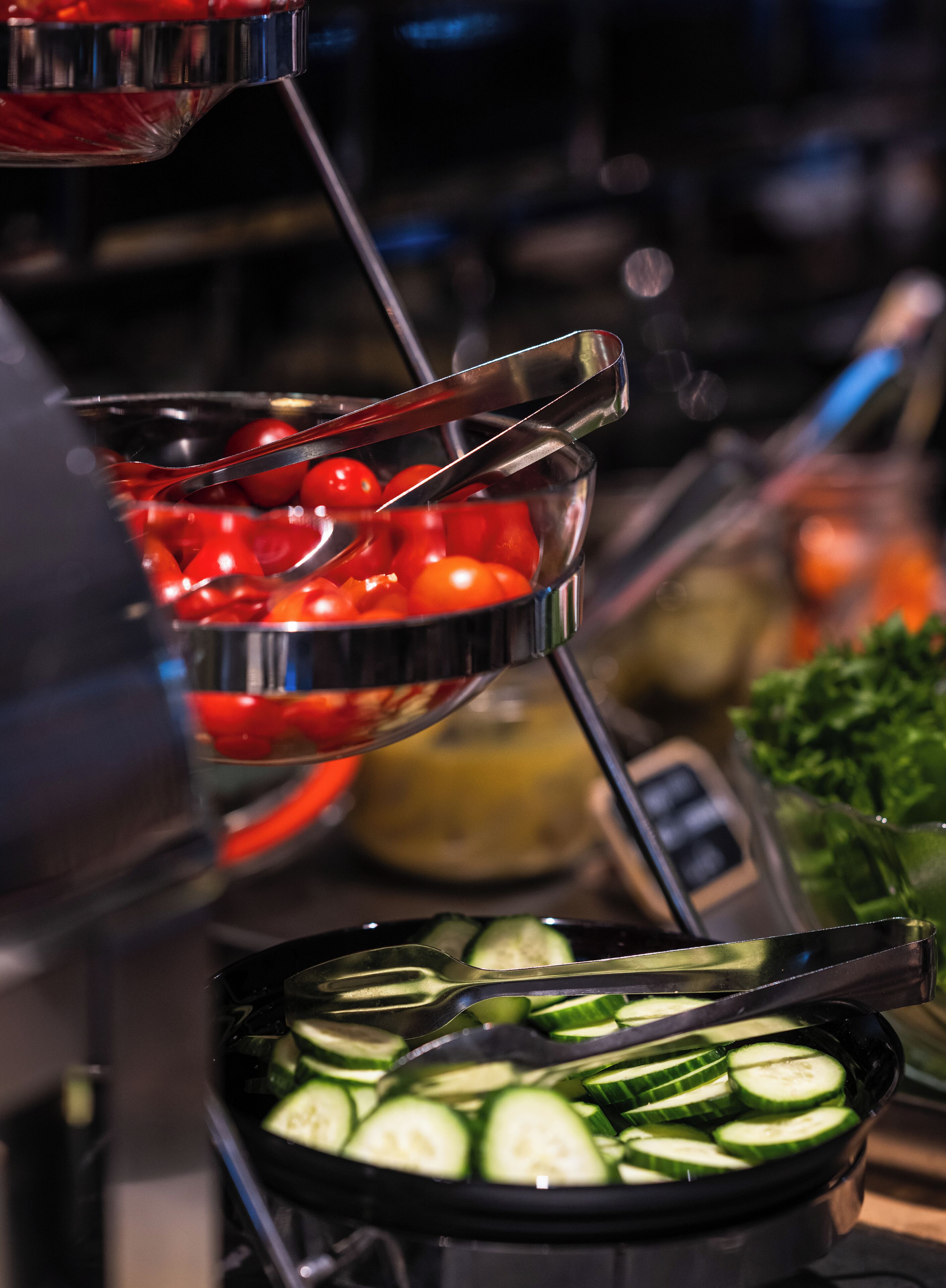 Un bufé con diversos alimentos, incluyendo tomates y pepinos.