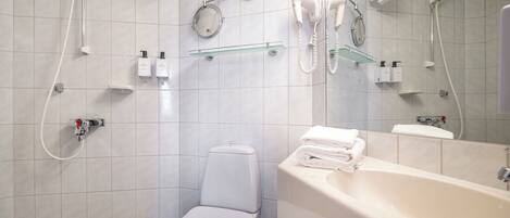 Un baño moderno con inodoro, lavamanos y ducha.