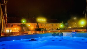A hot tub area with a view of a hotel named "Hotel Jotipuu" in the background. - Hotelli Jokipuisto (Kotka)