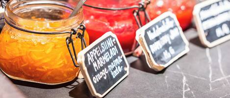 Three jars of marmalade with a spoon in each, and a sign indicating the marmalade is made from orange marmalade.