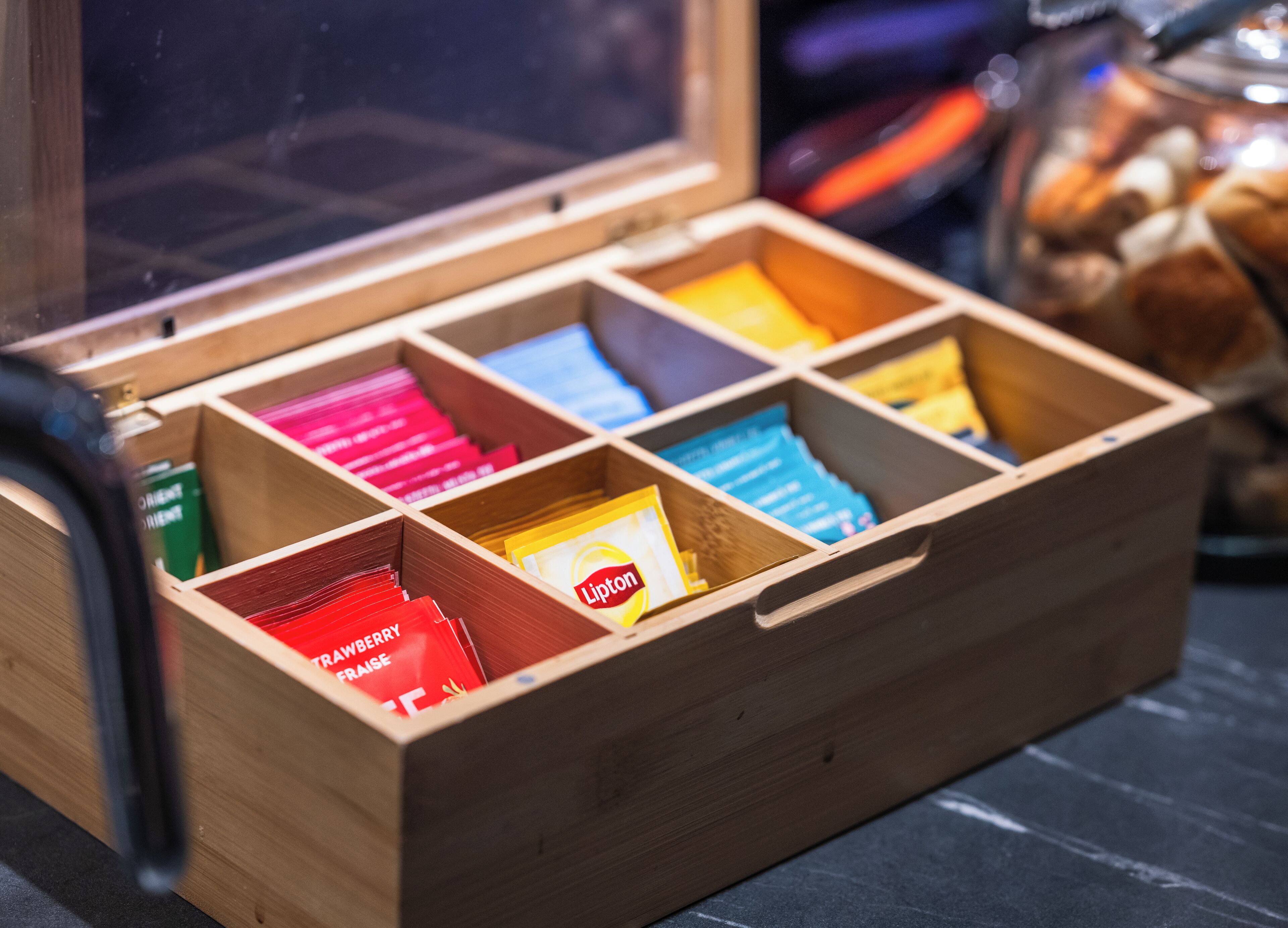 Una caja de madera con compartimentos que contienen diversos objetos.