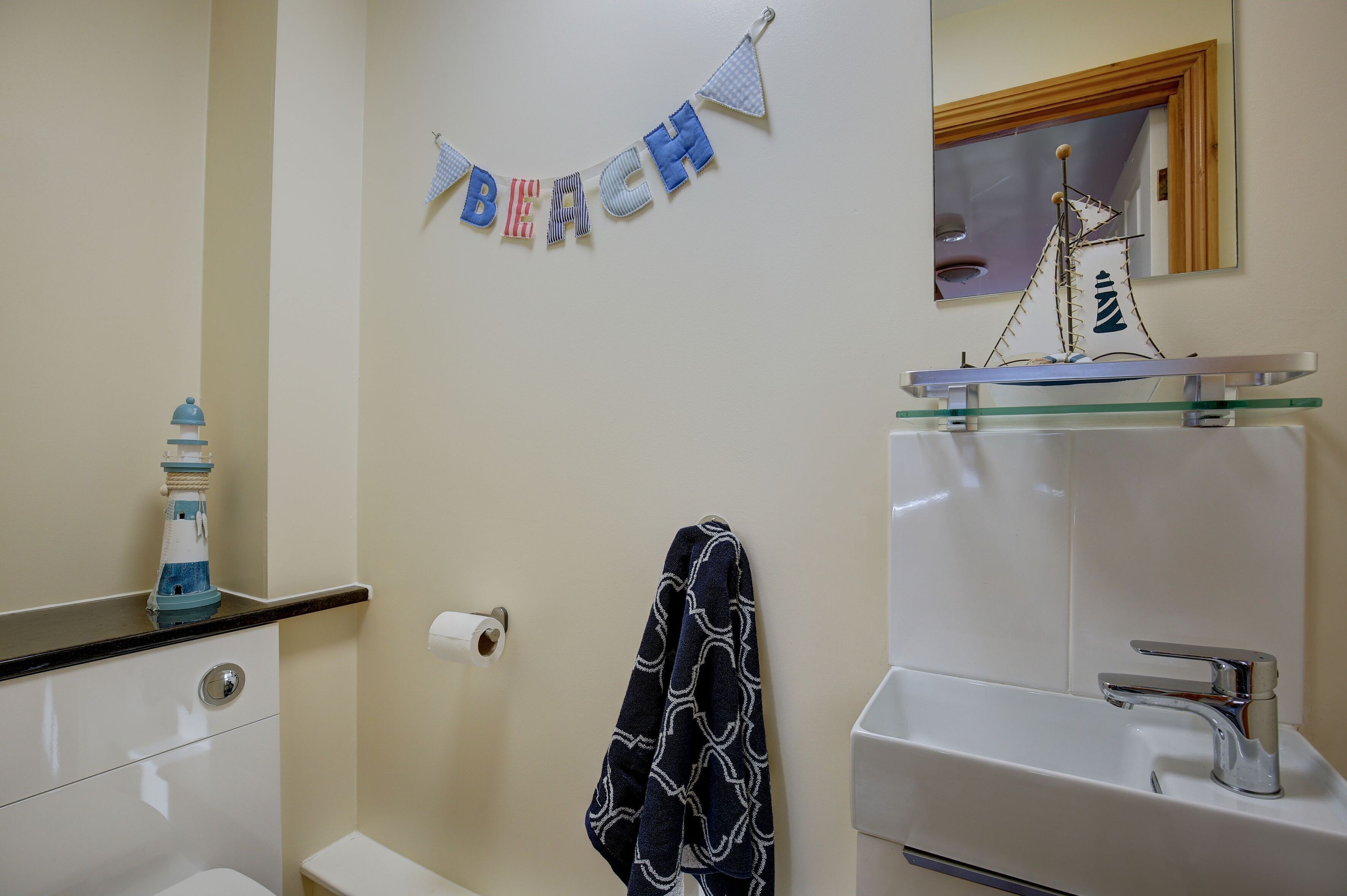 Une salle de bain avec des toilettes, un lavabo et une serviette accrochée au mur.