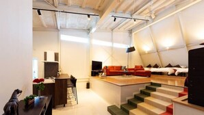 A modern interior with a kitchen area, a dining table, a sofa, and a staircase. - Ms Studio (Asahikawa)
