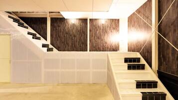 A modern interior with a staircase, wooden panel walls, and a light-colored floor.