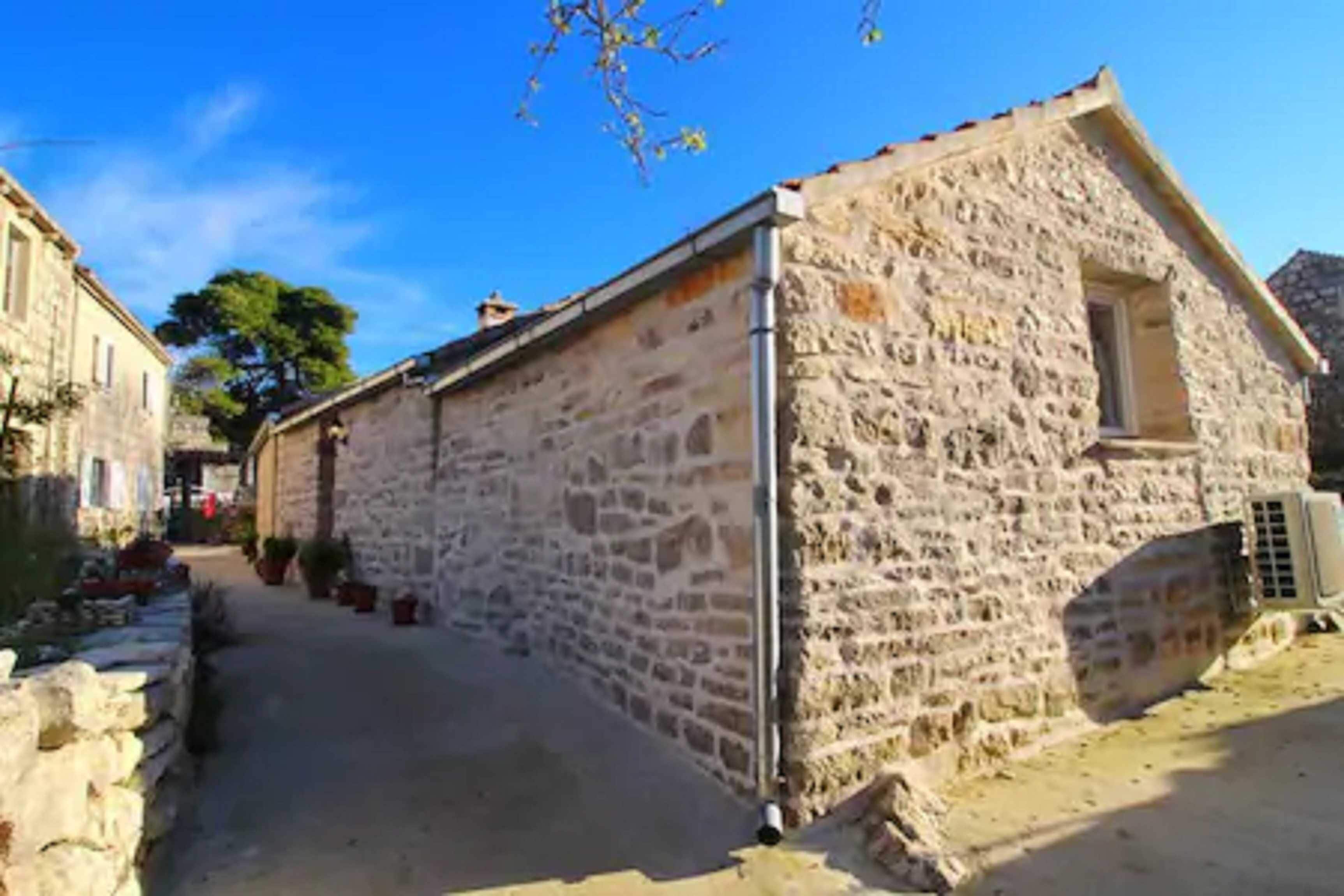 A stone building with a sloped roof, a narrow entrance, and a small window.