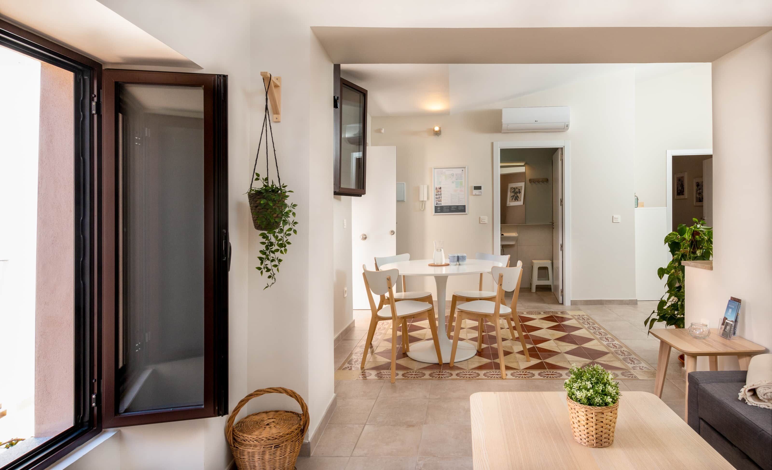 Un espacio habitable moderno con comedor, cocina y balcón.