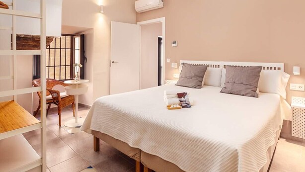 Une chambre d’hôtel avec un grand lit, un bureau et une chaise.