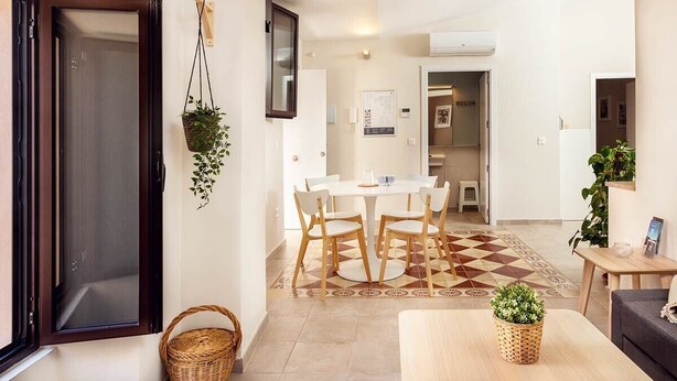 Una sala de estar moderna con sofá, una mesa de centro y un comedor con mesa y sillas.