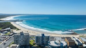Ein Küstenhotel mit mehreren Gebäuden, einem Strand und freiem Blick auf den Ozean.