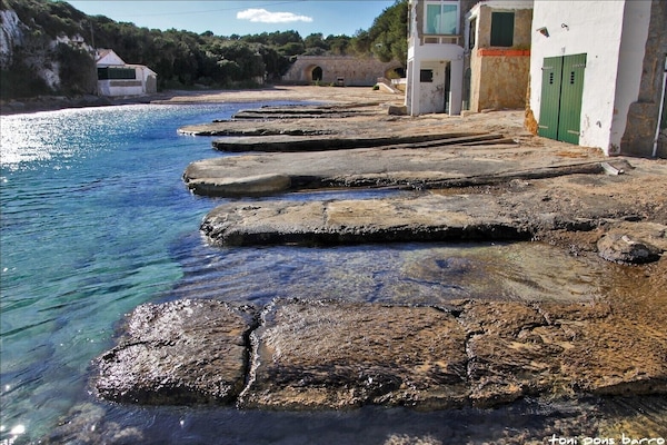 La Calanque d'Alcaufar avec sa plage de sable blanc et ses quais de pécheurs