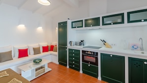 A modern kitchen with white and green cabinetry, a built-in oven, and a white countertop. - Maison de Pécheurs à 1mn à Pied de la Plage Cala Alcaufar (Alcaufar)