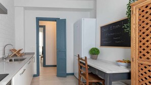 A modern kitchen with a white countertop, a sink, and a wooden chair. There is a chalkboard with "Welcome" written on it. - KUIA apartment in Barakaldo, next to the metro (Barakaldo)
