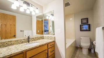 Bathtub, hair dryer, towels, shampoo