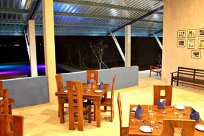 Dine under the stars in a serene outdoor setting with comfortable seating and beautifully set tables.