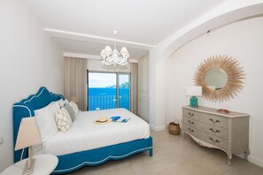 A bedroom with a bed, a dresser, a chandelier, a mirror, and a view of the sea. - Terrazze di Laurito, at 3 kms from Positano (Positano)