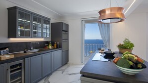 A modern kitchen with grey cabinets, a marble floor, and a view of the sea through a sliding glass door. - Terrazze di Laurito, at 3 kms from Positano (Positano)