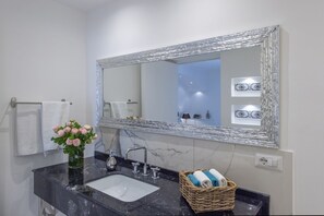 A bathroom with a marble sink, a large mirror, and a wicker basket with towels. - Terrazze di Laurito, at 3 kms from Positano (Positano)