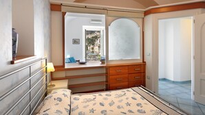 A bedroom with a bed, a dresser, a mirror, and a view of a balcony. - Dolce Vita B by Amalfi Beaches (Amalfi)
