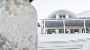 Un edificio moderno con techo curvo y fachada blanca.