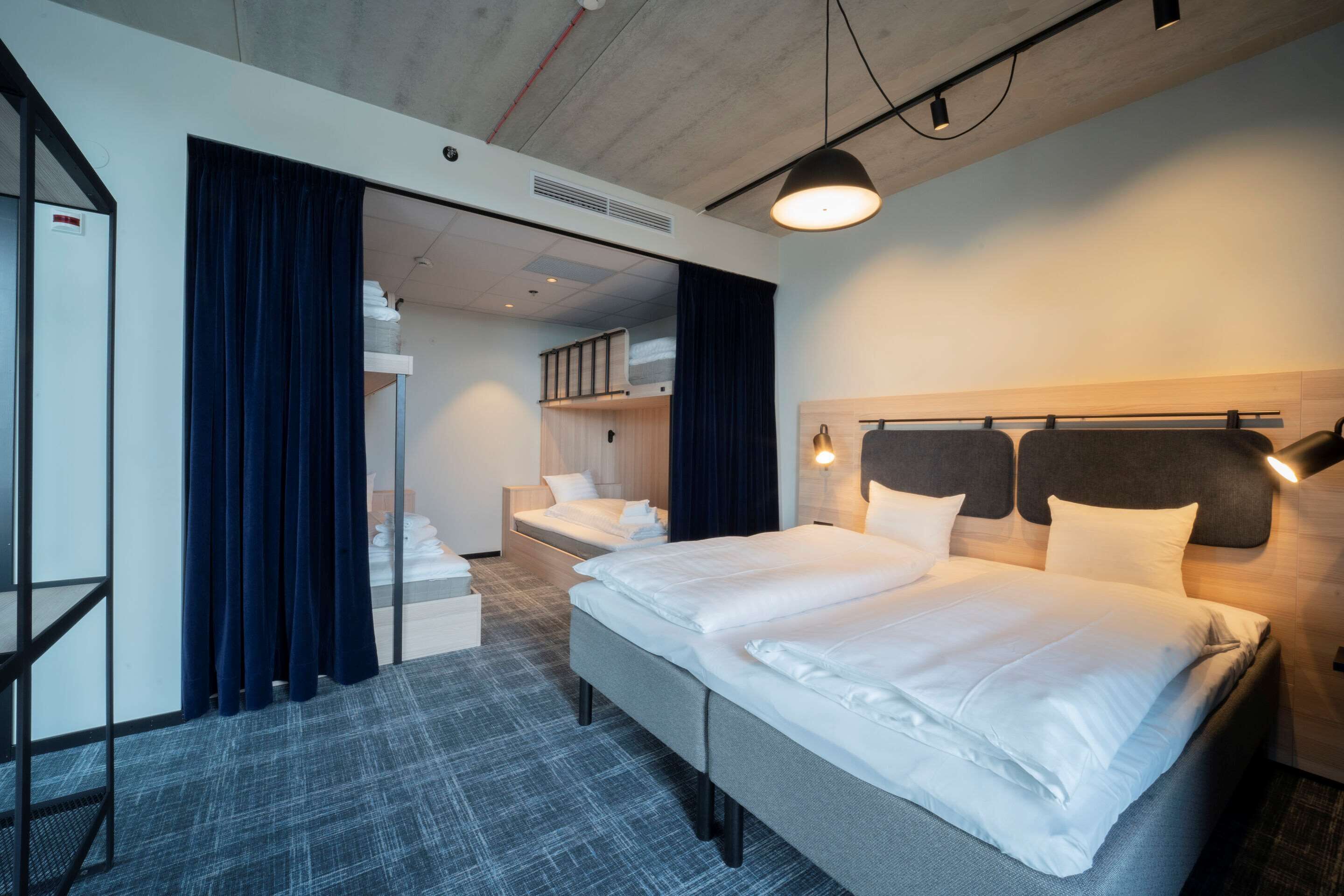 Ett hotellrum med en stor säng, ett skrivbord och en garderob.