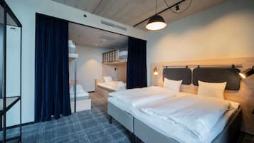 Una habitación de hotel con una cama grande, un escritorio y un armario.
