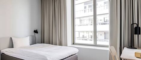 Quarto moderno com cama, escrivaninha e uma cadeira.