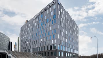 Een modern Comfort Hotel gebouw met een opvallend bord, een trap die naar de ingang leidt en een helder uitzicht op de omgeving.