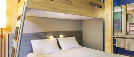 A bunk bed with a wooden headboard, a bedside table, and a mirror.