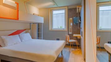 Una camera d'albergo moderna con un letto a castello, una scrivania, una sedia e una televisione.