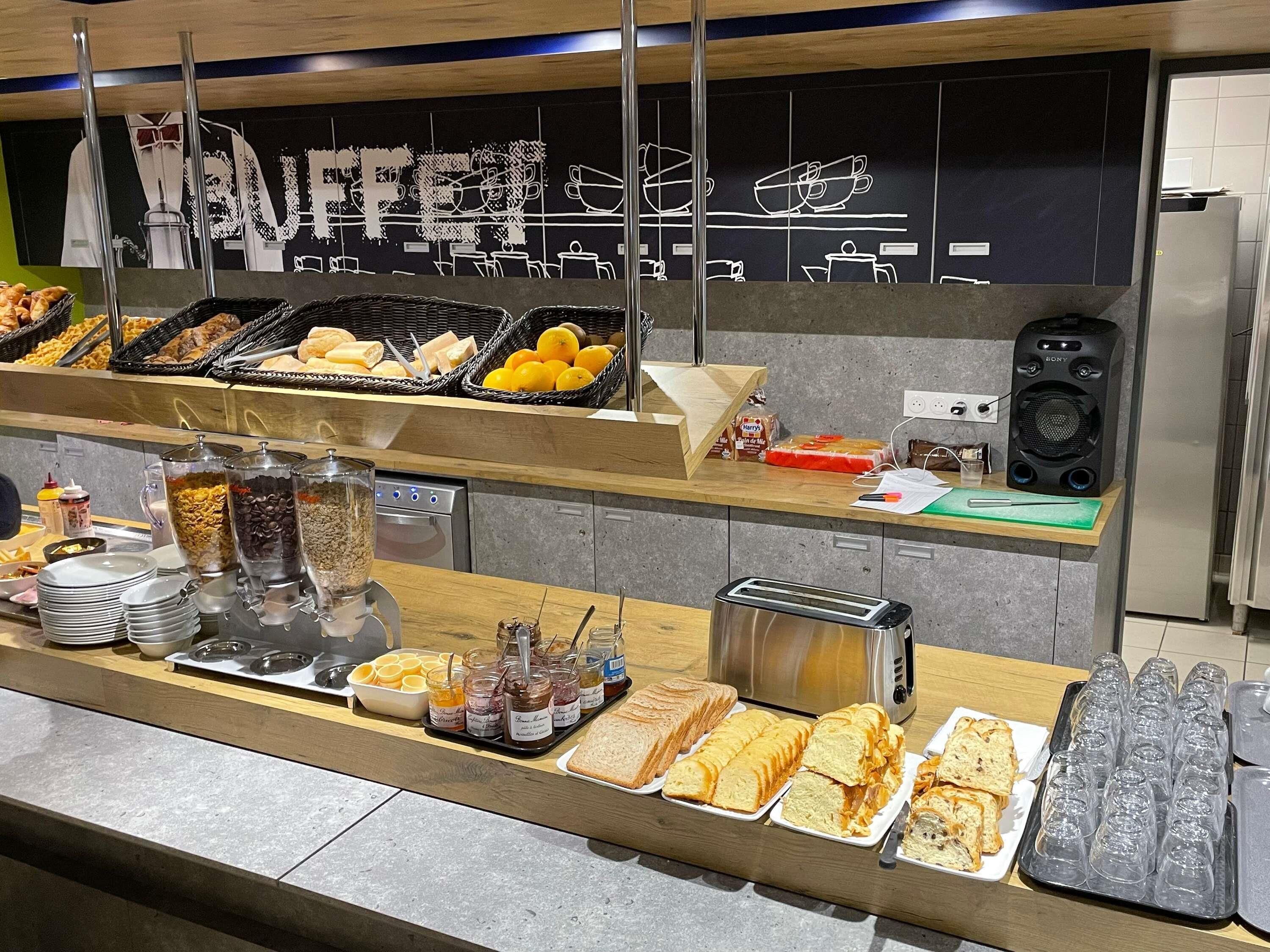 Un mostrador de buffet con diversos alimentos, una máquina de café y un tostador.
