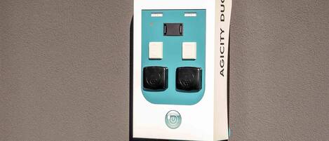A teal and white power outlet box labeled 'AGILITY DUO' against a textured wall.