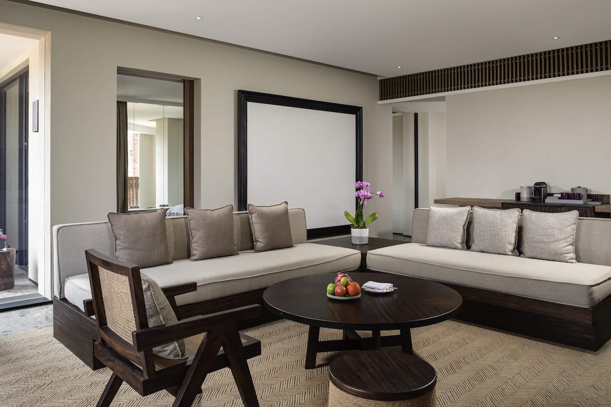 A modern living room with a sectional sofa, a round coffee table, and a small side table with a potted orchid.