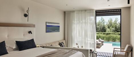 Een moderne hotelkamer met een groot bed, uitzicht op een zwembad en een balkon met buitenmeubels.