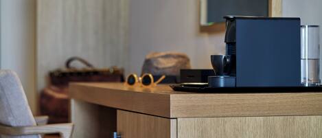 A modern kitchen with a coffee machine, a bag, and a pair of sunglasses on the counter.