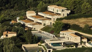 Um resort moderno com vários edifícios, uma piscina e área ajardinada.
