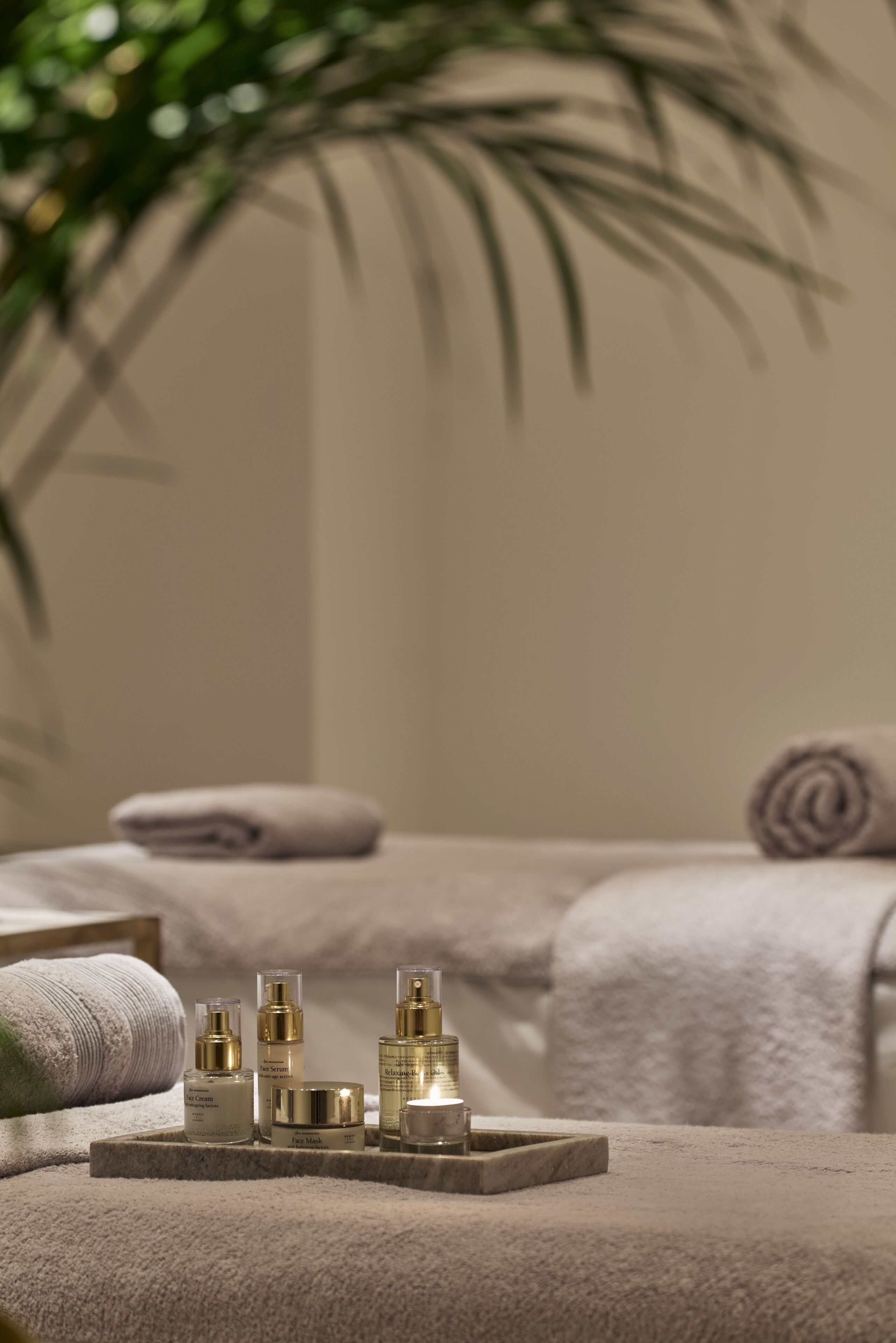 A spa setting with a massage table, towels, and skincare products.