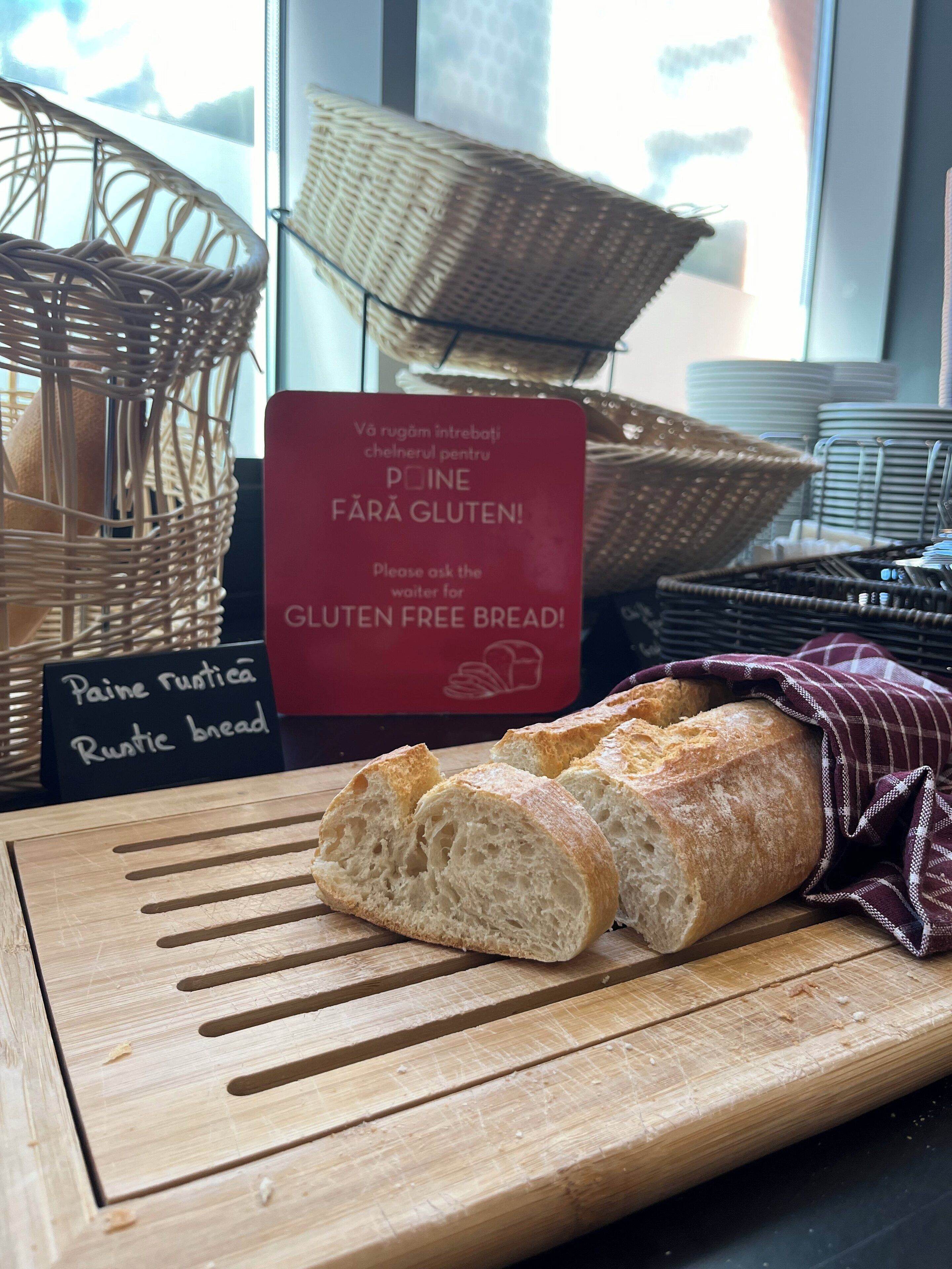 Ein glutenfreies Brot auf einem Holzschneidebrett, mit einem Schild, das die Verfügbarkeit anzeigt.