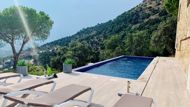 A poolside area with lounge chairs, a small table, and potted plants. - Holiday house in a unique quiet location - sea view - private pool - Internet (Roses , Mas Fumats)