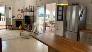 A modern kitchen with a wooden countertop, stainless steel appliances, and a dining area with a table and chairs. - Holiday house in a unique quiet location - sea view - private pool - Internet (Roses , Mas Fumats)