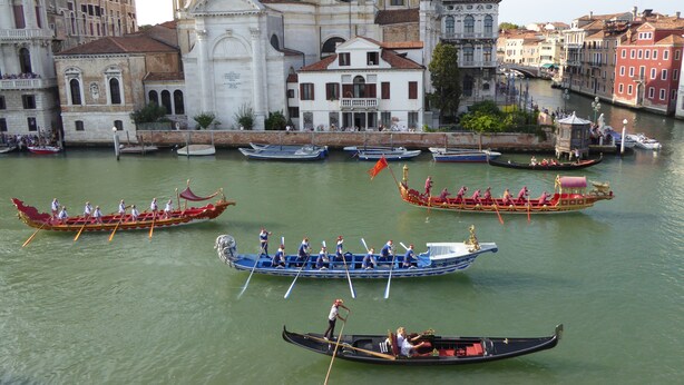 Gondolas en un canal con edificios históricos al fondo.