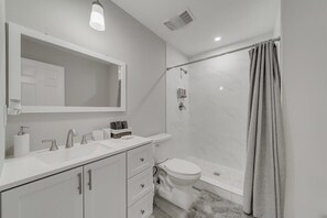 Bathtub, hair dryer, towels, shampoo