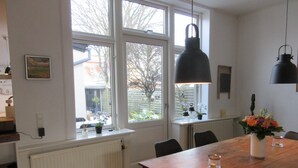 Een eethoek met een houten tafel, stoelen en een raam met uitzicht.