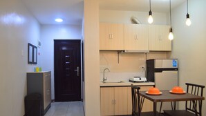 A compact kitchen with a dining area, featuring cabinets, a sink, a stove, and a refrigerator. - Dencio's Crib (Lapu-Lapu City)