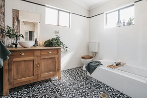 Bathroom features a large basin, toilet, and bathtub.